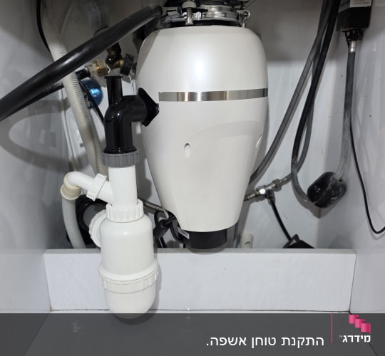 מתקן אינסטלציה מתחת לכיור במטבח